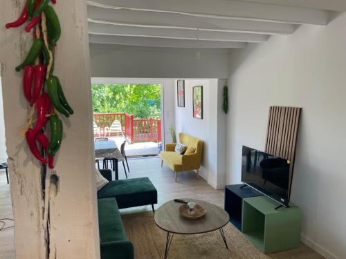 a living room with a couch and a tv and a table at Large Apartment with Mountain View in Espelette in Espelette