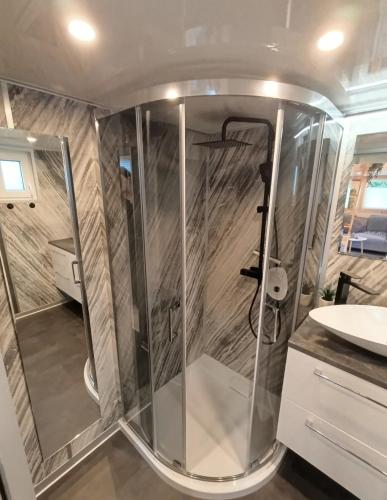 a shower in a bathroom with a sink at Tiny House mit Saunafass im Wendland in Lüchow