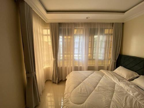 ナイロビにあるParkhust Staysの白いベッドと窓のある寝室