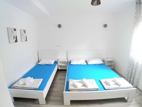 two beds in a room with white and blue at Apartment Nina in Gevgelija