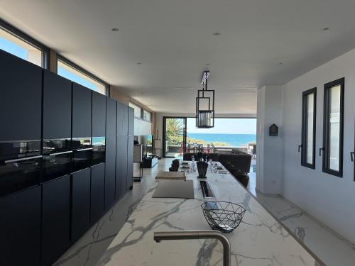 - une cuisine avec des armoires noires et une vue sur l'océan dans l'établissement Villa Carrare - Bien d'exception face à la mer, au Cap d'Agde