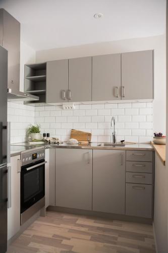 a kitchen with stainless steel appliances and white cabinets at Mörrum River Residences in Mörrum