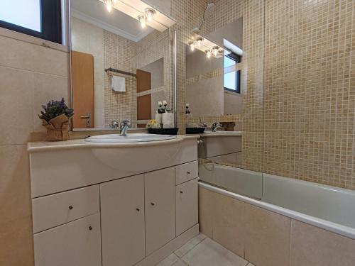 アルマカオ・デ・ペラにあるT3 RC Navegantes - Casas & Papeisの洗面台、浴槽、鏡のあるバスルーム