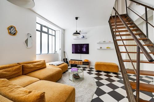 un salon avec un canapé et un escalier dans l'établissement Beautiful Loft#Canal St-Martin#2bedrooms, à Paris