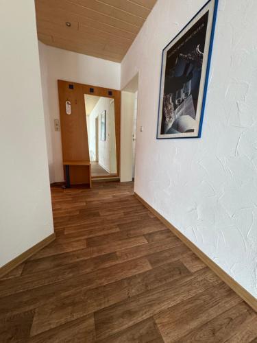 a hallway with wooden floors and a picture on the wall at Pension Werre Stern in Bad Oeynhausen
