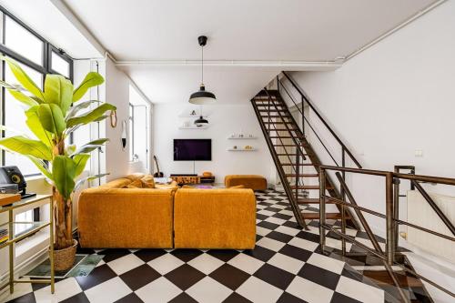 un salon avec un canapé et un escalier dans l'établissement Beautiful Loft#Canal St-Martin#2bedrooms, à Paris