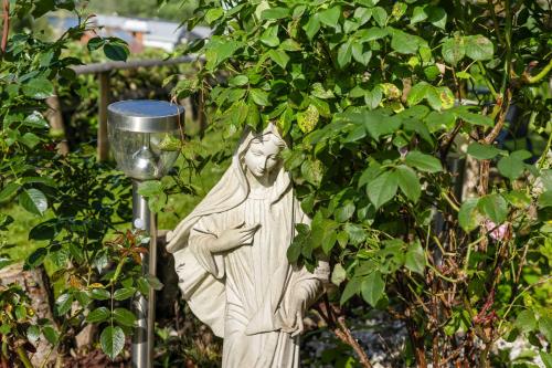a statue of a woman standing next to a tree at Pension Magdalena in Altossiach