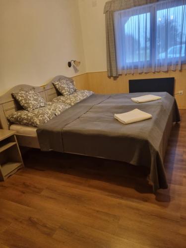 a large bed in a room with a window at Nemeskerék Vendégház in Nemesnép