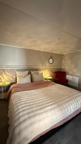 une chambre avec un grand lit avec une horloge au mur dans l'établissement escapade, à La Celle-sous-Gouzon