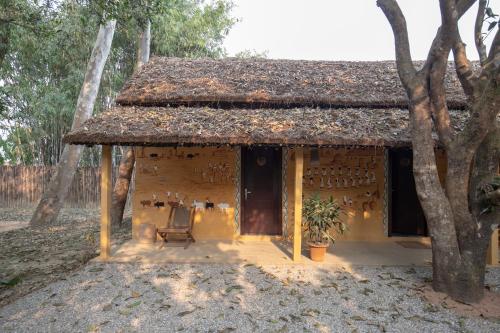 a small house with a chair in front of it at Unnati Cultural Village Hospitality in Maruwā Ghāt