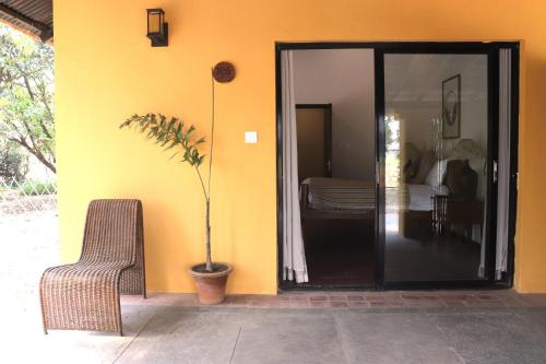 a patio with a chair and a plant next to a building at Unnati Cultural Village Hospitality in Maruwā Ghāt
