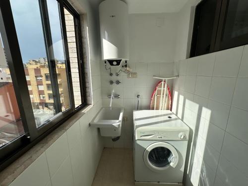 a small bathroom with a washing machine and a sink at Sirocco Apartamento in Oropesa del Mar