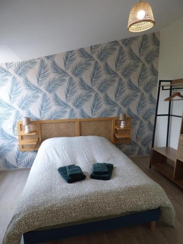 une chambre avec un lit avec deux oreillers verts dessus dans l'établissement Les Frères Caudron, appartement centre ville, au Crotoy