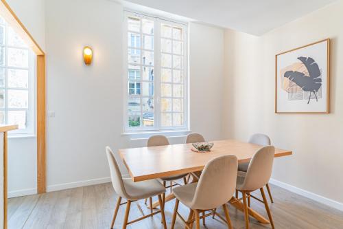 une salle à manger avec une table et des chaises en bois dans l'établissement Appartement 2 chambres en Hyper Centre avec balcon, à Bordeaux