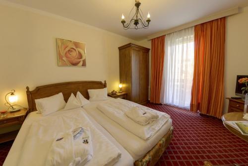 a bedroom with a large bed with white sheets at Das Moerisch in Seeboden