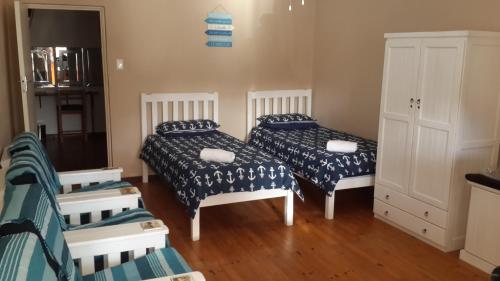 a room with two beds and a cabinet at Bellevue Resort Stilbaai Nr.7 in Stilbaai