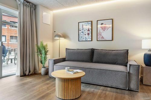 a living room with a couch and a table at 4-Person Midtown Apartment w Easy Access in Aarhus