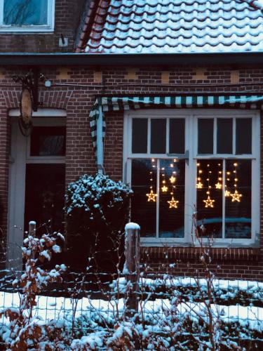a house with christmas lights in the windows at Slapen bij de Brug in Zuidveld