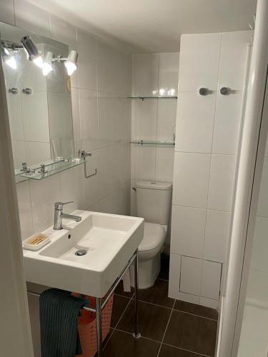 une salle de bain blanche avec un lavabo et des toilettes dans l'établissement Le Côté Sud Calme, Piscine, 20 min de St-Tropez, à La Garde-Freinet