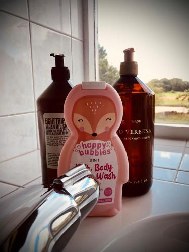 a bottle of happy bubbles and a bottle of body wash at Slapen bij de Brug in Zuidveld