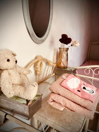 a teddy bear sitting on a chair next to a table at Slapen bij de Brug in Zuidveld