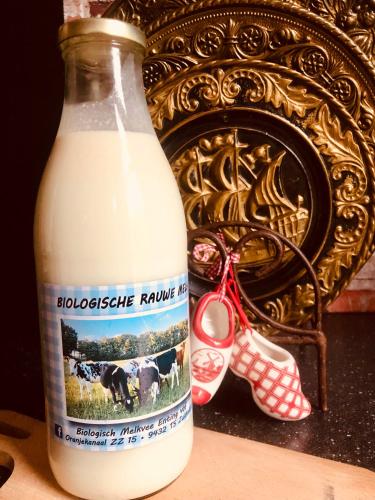 a bottle of milk next to a pair of scissors at Slapen bij de Brug in Zuidveld