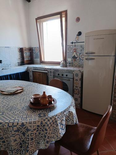 a kitchen with a table and a white refrigerator at Agriturismo Fattoria Alessandrini in Principina Terra