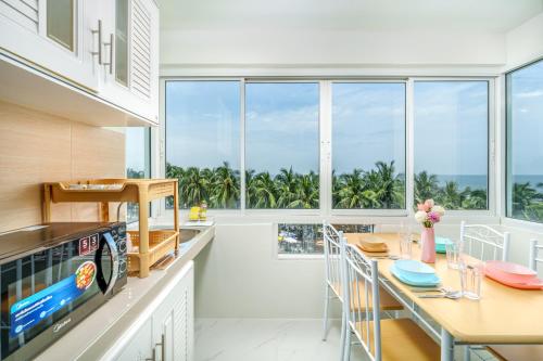 a kitchen with a dining table with a view of the ocean at Bang Saen Royal Beach by Sea view Bang Saen in Ban Laem Thaen
