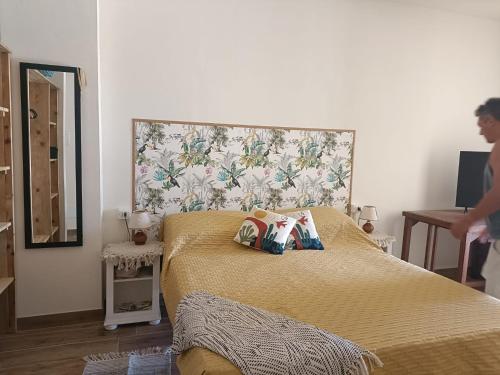 a bedroom with a bed with a yellow bedspread at Agriturismo Fattoria Alessandrini in Principina Terra