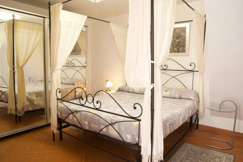 a bedroom with a four poster bed and a mirror at La casa al vicolo in Paliano