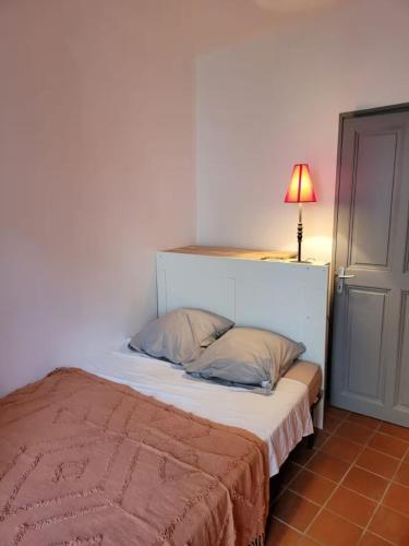- une chambre avec un lit et une lampe au-dessus dans l'établissement Maison de ville Intramuros en Duplex avec Patio, à Avignon