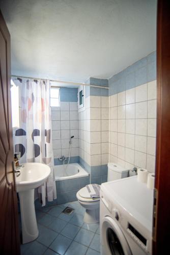 a bathroom with a sink and a toilet and a tub at Theros Apartment Preveza in Preveza