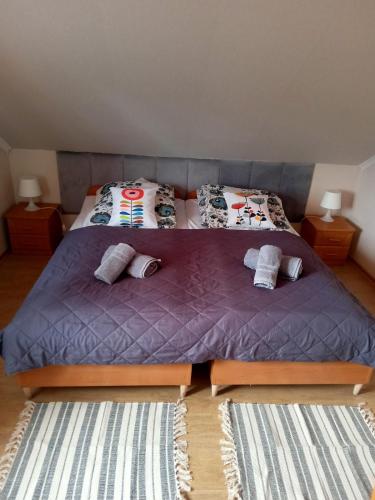 a bedroom with a large purple bed with two pillows at Stary Drahim in Czaplinek