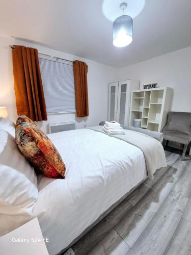 a bedroom with a large white bed with a pillow on it at Robinhuts Views Apartments in London