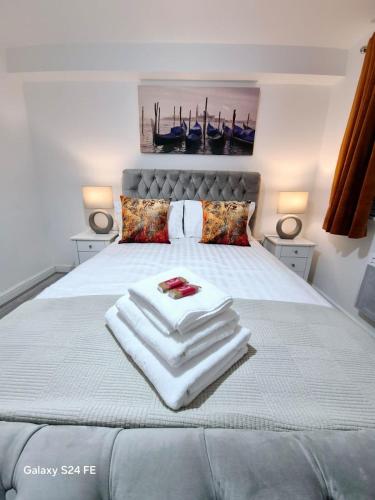 a bed with a pile of towels on it at Robinhuts Views Apartments in London