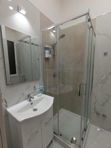 a bathroom with a glass shower and a sink at Le follie in Maddaloni