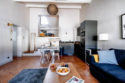 un salon avec un canapé et une table dans l'établissement La Lucarne du Palais - Clim et Wifi - Vue sur le Palais des Papes à 20m, à Avignon