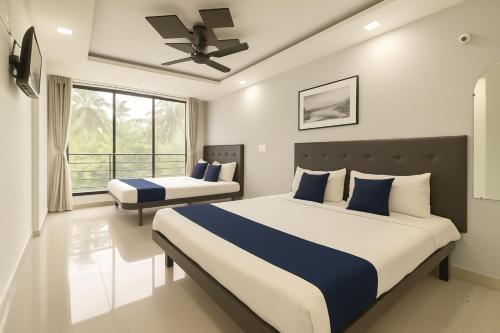a bedroom with two beds and a ceiling fan at Apartments and Studio and Villas in GOA in Calangute