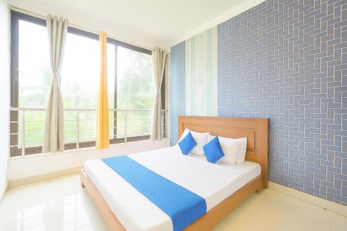 a bedroom with a bed with blue and white pillows at Apartments and Studio and Villas in GOA in Calangute