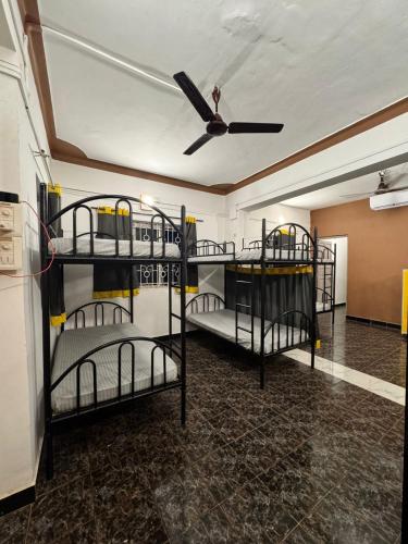 a room with three bunk beds in it with a ceiling at Paradise A Social Hostel in Anjuna