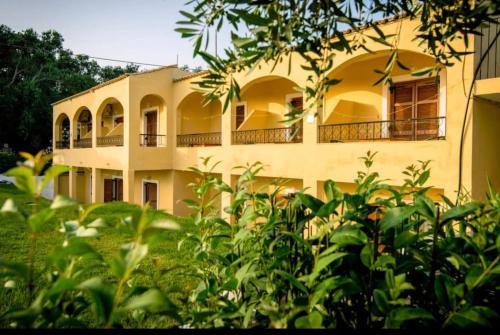 a large yellow building with balconies on it at Agrilia Studios No 5 in Agios Georgios Pagon