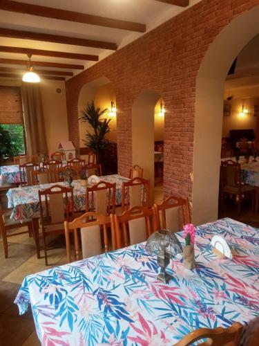 a dining room with tables and chairs and a brick wall at Stary Drahim in Czaplinek