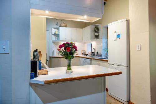 a kitchen with a vase of flowers on a counter at GreyCot in Greyton