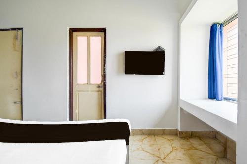 a white room with a chair and a window at Super Hotel O Dumduma Near DN Regalia Mall in Bhubaneshwar