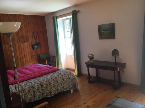 une chambre avec un lit, une table et une fenêtre dans l'établissement Détente assurée au moulin de papalis, à Ribérac