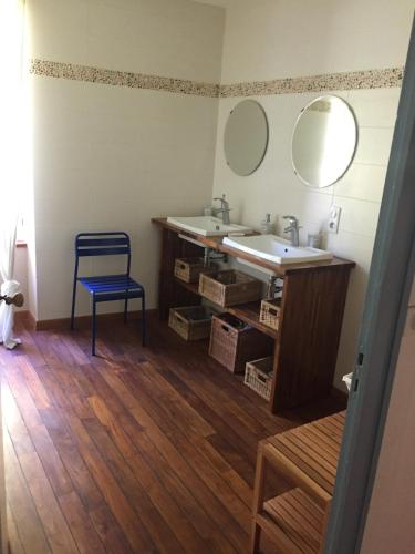 La salle de bains est pourvue d'un lavabo et d'une chaise bleue. dans l'établissement Détente assurée au moulin de papalis, à Ribérac