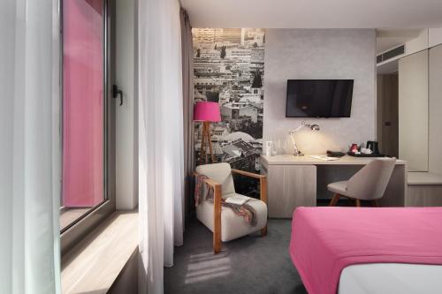 a bedroom with a bed and a desk with a table at Hotel Colors Inn in Sarajevo
