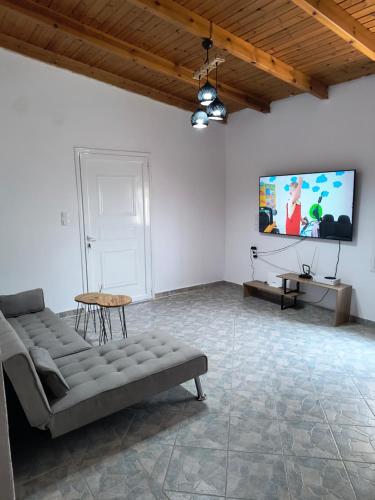 a living room with a couch and a flat screen tv at Summer house, Μονοκατοικία 120 in Eretria