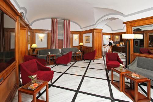un soggiorno con sedie e tavoli rossi di Hotel Arcangelo a Roma
