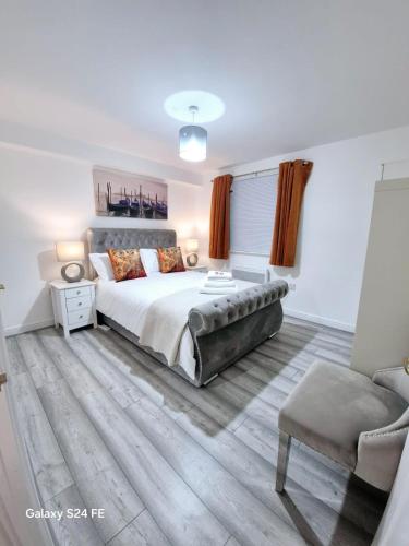 a bedroom with a large bed and a chair at Robinhuts Views Apartments in London